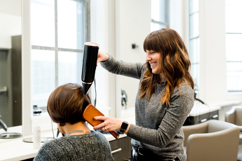 Stylist blow-drying a client's hair into a smooth finish